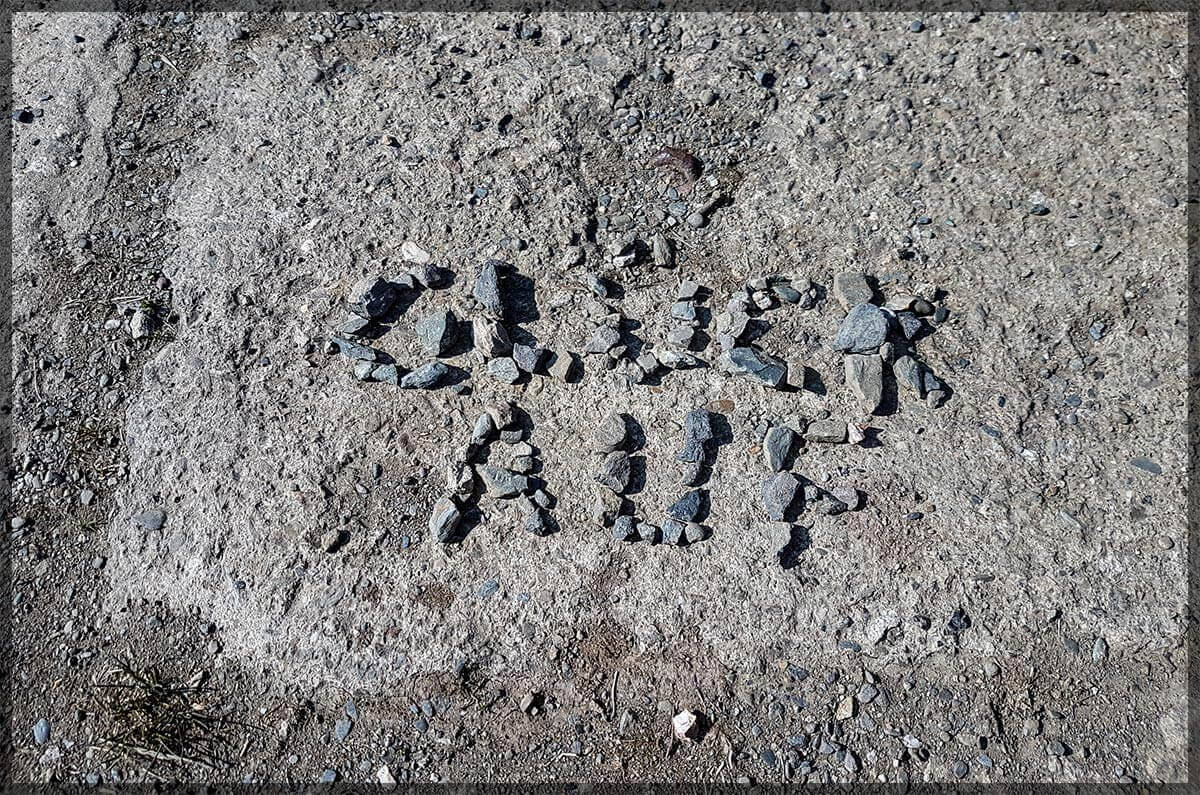 Eisenerzgrube Freundlicher Gruß - Glück Auf! Eine aus Steine gelegte Nachricht neben dem Auto.